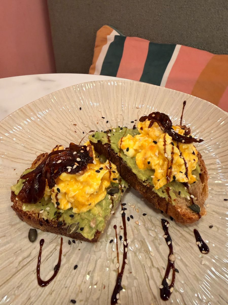 Eggy Avo — chopped eggs and smashed avocado on artisan toast, served on the pink Hora Mansa banquette.