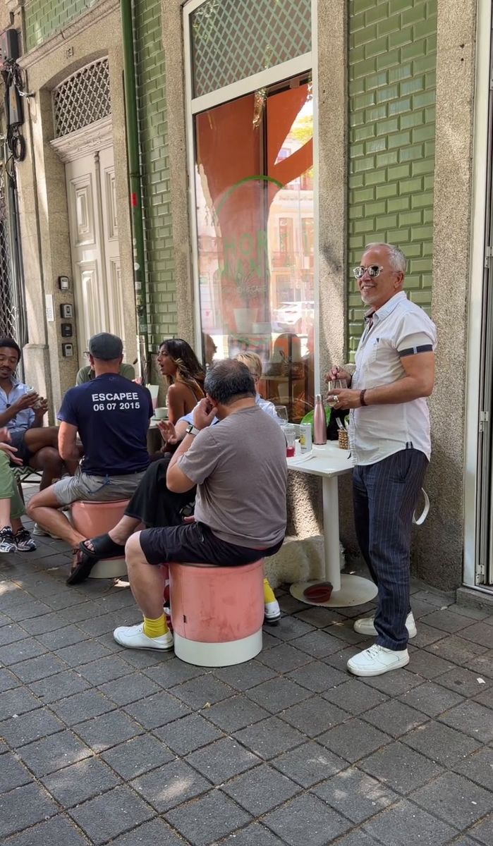 Guests gathered outside Hora Mansa's sage-tiled façade during a private event, drinks in hand on the pink stools.