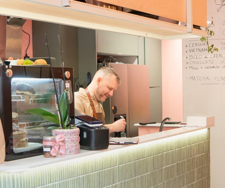 Terrance, the founder of Hora Mansa, at the counter beside the cake display.